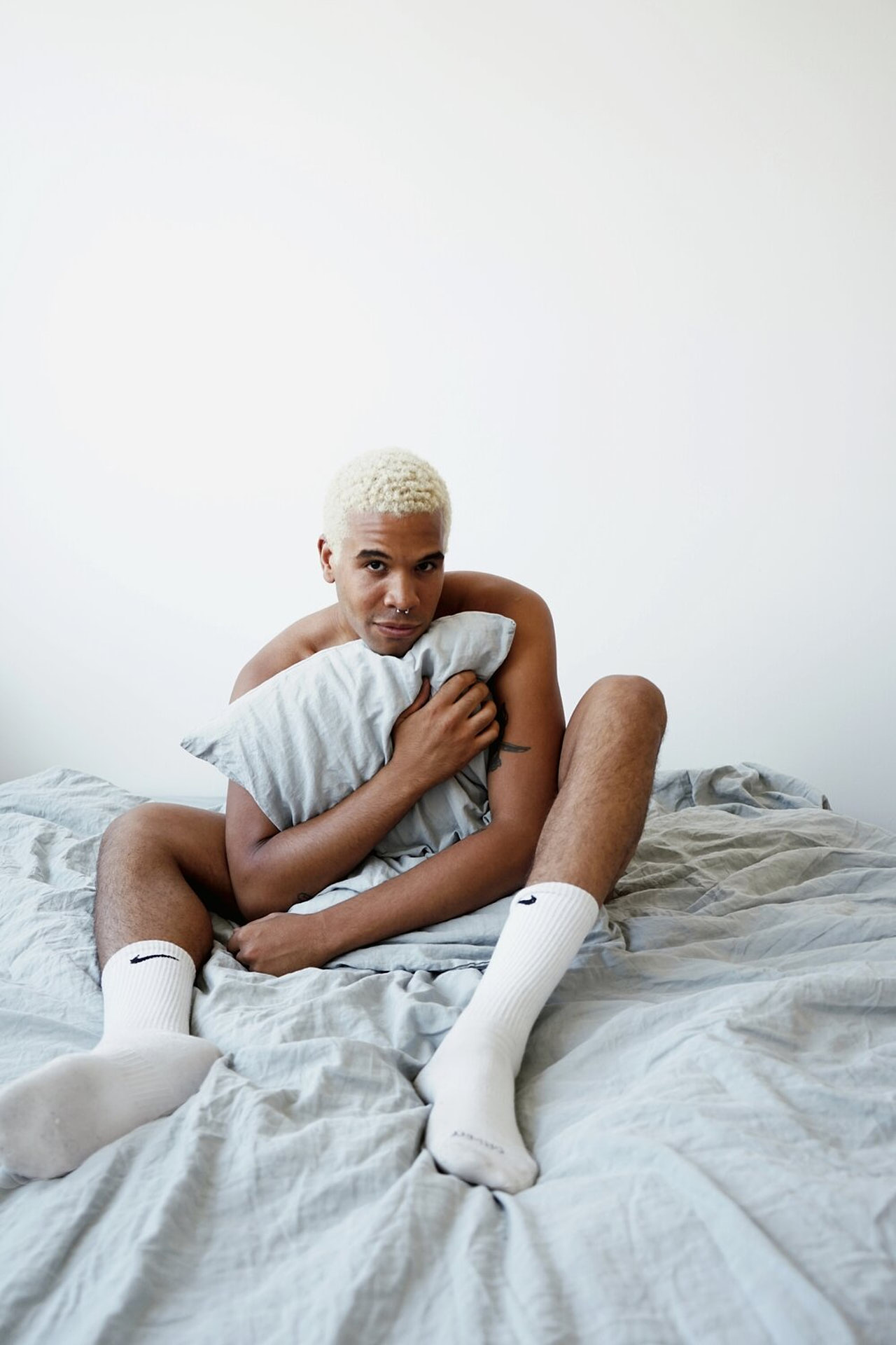 Man Hugging Pillow in Nike Socks